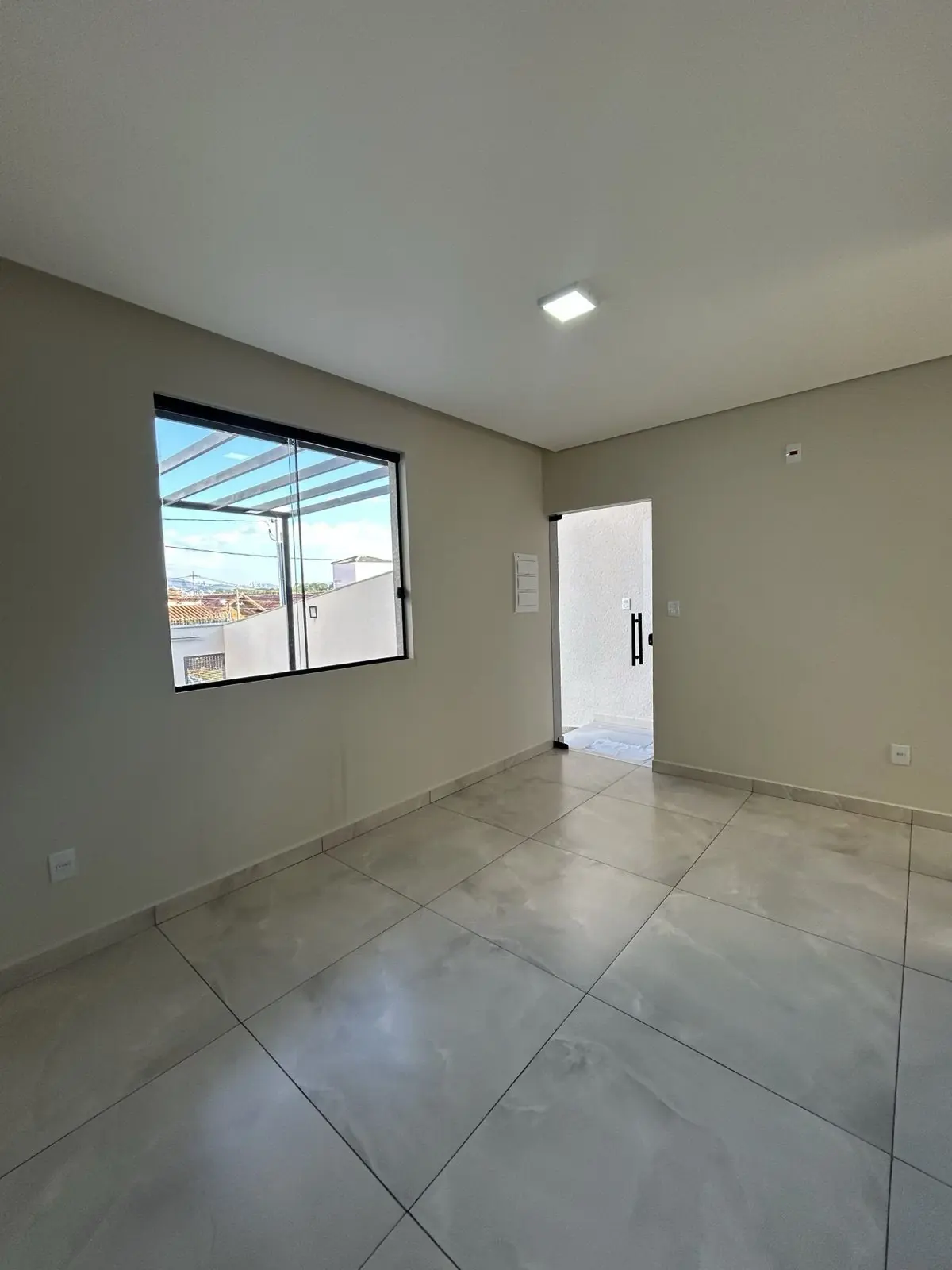 Sala ampla com porcelanato e janela