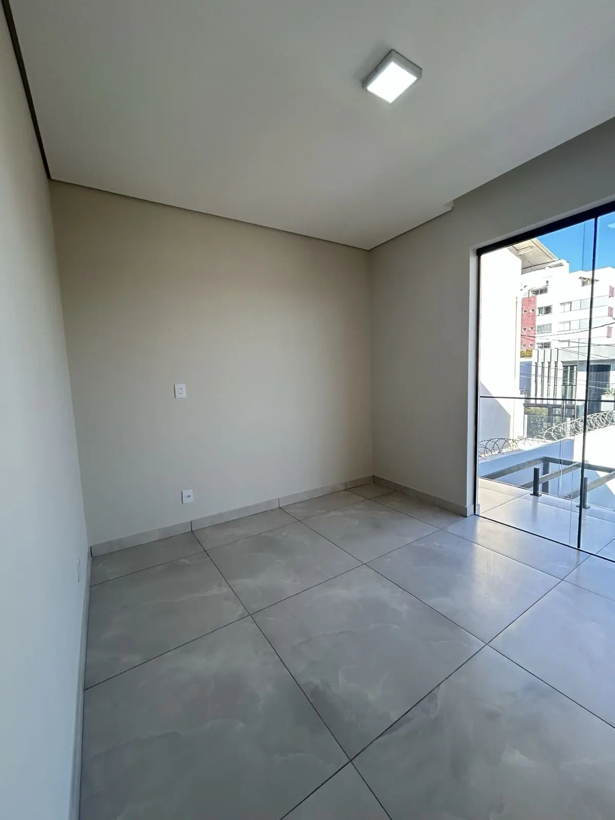 Quarto com porta de vidro para a sacada